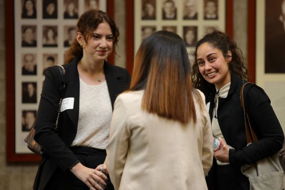 Three women standing and talking.